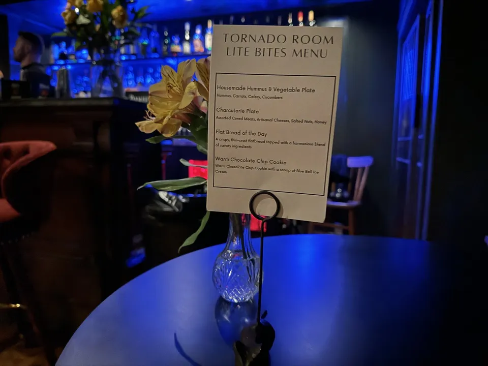 The printed Tornado Room Lite Bites card on a table, the backbar behind it.